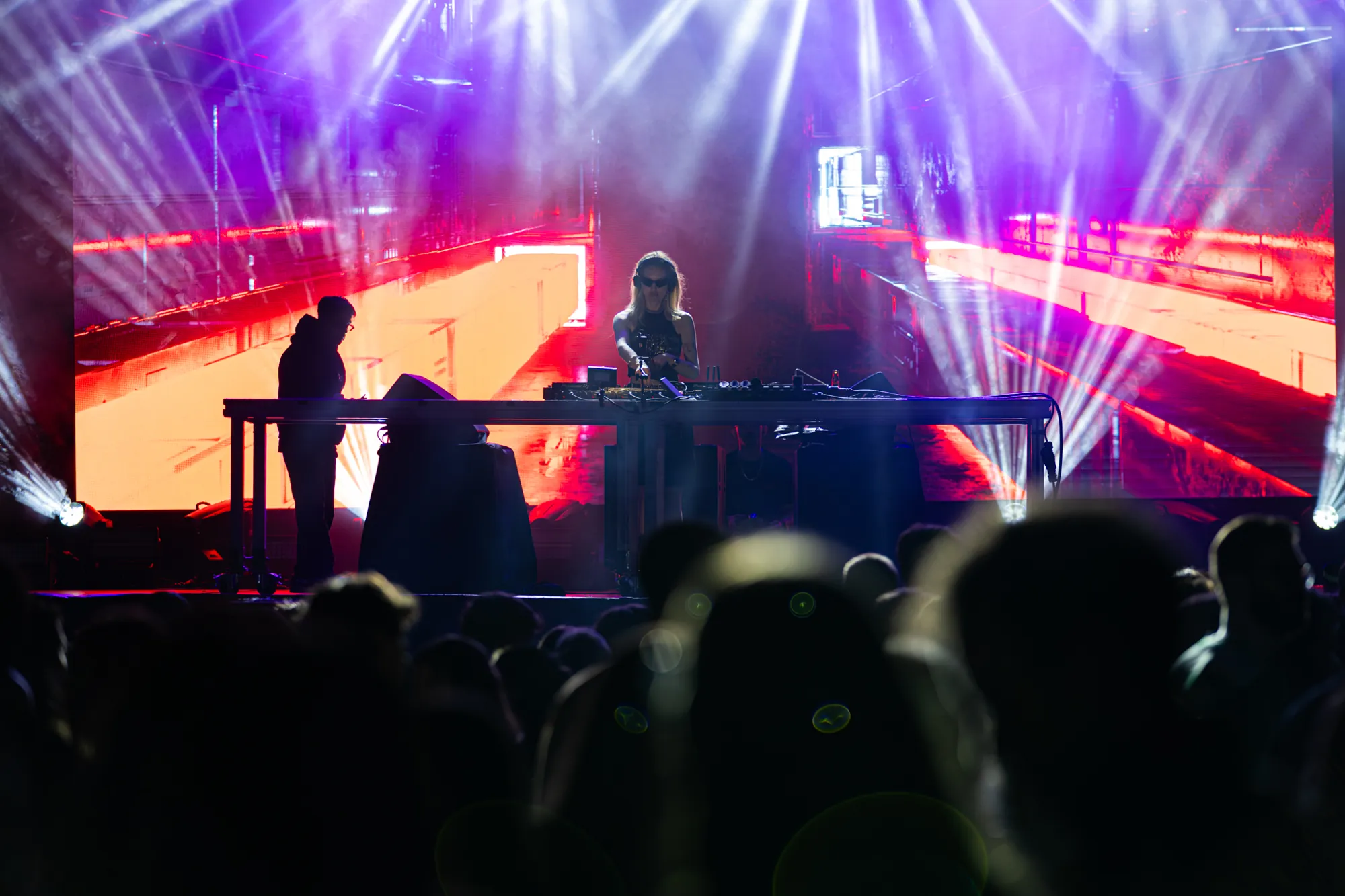 DJ no palco principal do 231 Fest, com feixes de luz e ecrã gigante sobre o público